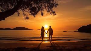 A couple walking on the beach holding hands.
