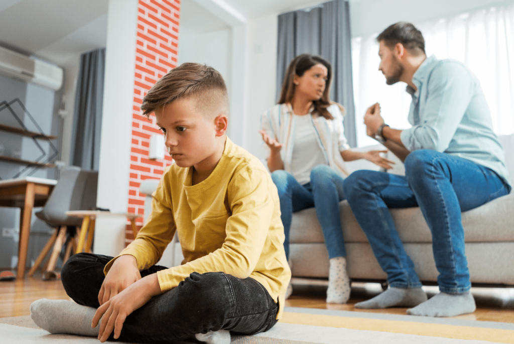A couple arguing and a young boy nearby looks emotional. 7 things to do when your children see you arguing